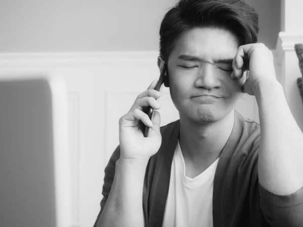 アジアの若い男摩擦彼の疲れ目彼のスマートフォン — ストック写真