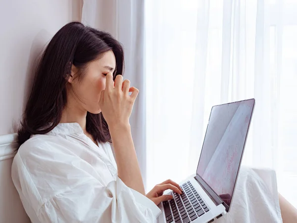 Asian Young Woman Rubbing Her Tired Eyes Using Laptop — Stock Photo, Image
