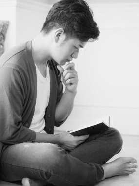 Not defterine yazı yazan çapraz bacaklı genç Asyalı..