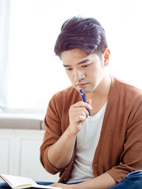 Not defterine yazan Asyalı genç adam..