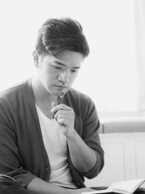 Not defterine yazan Asyalı genç adam..