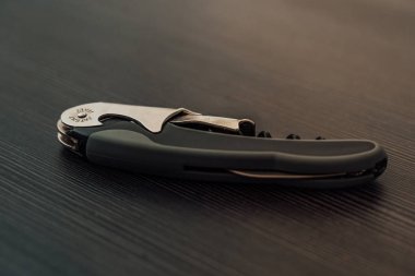 Siyah bir masanın üzerinde yatan birden fazla şişe açacağı