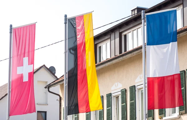 Drapeau allemand, drapeau suisse, drapeau français soufflant dans le vent (triangle frontalier ) Photo De Stock