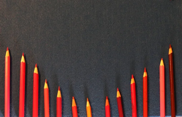粗斜纹棉布上的许多红色铅笔 — 图库照片