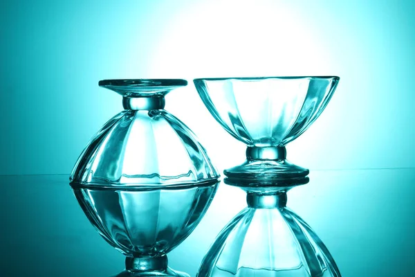 两个透明的玻璃碗在绿色的背景和他们的反射 侧视图 — 图库照片