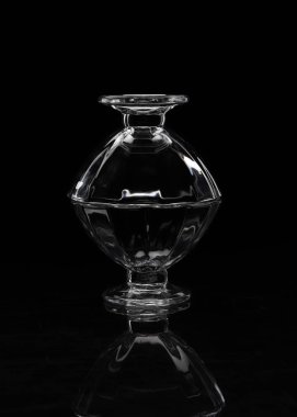 siyah bir zemin üzerine üst üste iki şeffaf cam vazo vurgulamaktadır