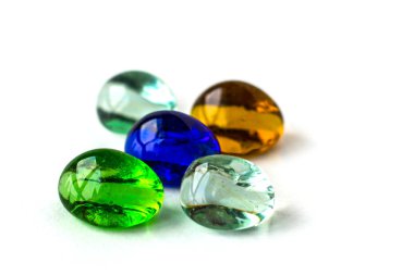 Renkli cam topları, yeşil, mavi, beyaz ve turuncu. Beyaz arka plan.