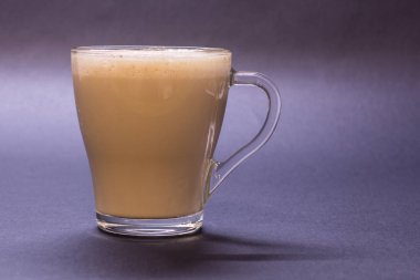 Şeffaf cam fincan kahve Menekşe arka plan üzerinde. Parlak sesi, yumuşak odak