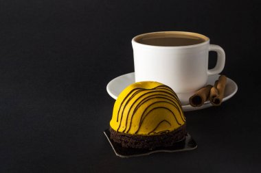 Mango tatlı pasta. Sıcak kahve ve Tarçın beyaz fincan siyah arka plan üzerinde izole sopa.