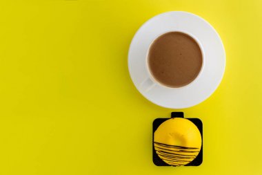 Mango tatlı pasta. Sarı arka planda izole sıcak kahve Beyaz fincan.