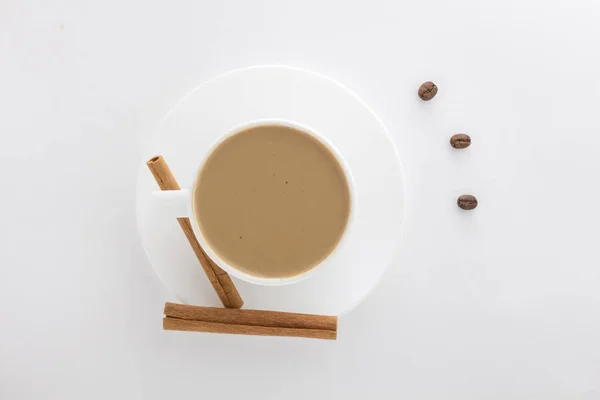 Белая чашка горячего кофе и коричные палочки  . — стоковое фото