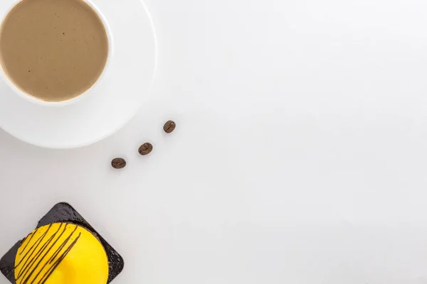 Weiße Tasse heißen Kaffee und Zimtstangen und Mango-Kuchen. — Stockfoto