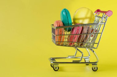 Sarı arka planda tatlı Fransız macaroons kek.