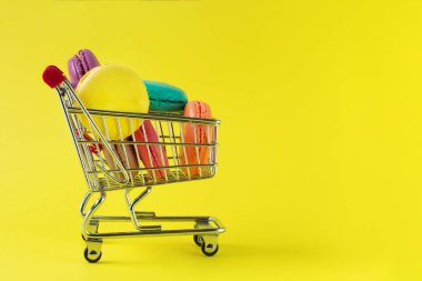 Sarı arka planda tatlı Fransız macaroons kek.