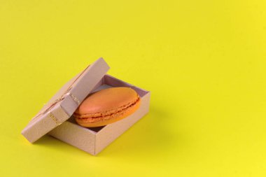 Macaroons kutunun üst görünümü. Sarı arka planda tatlı Fransız macaroons kek.