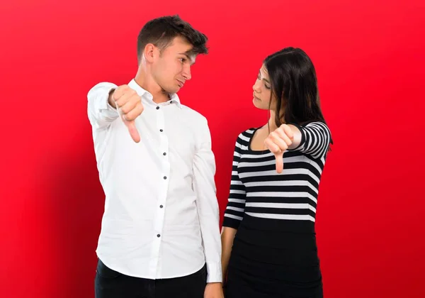 若いカップルを示す親指で下を否定表現と記号 — ストック写真