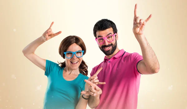 Couple in colorful clothes making crazy gesture