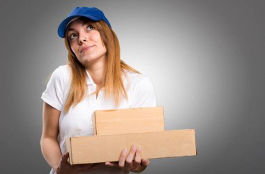 Gri arka plan üzerinde önemsiz jest yapma teslim kadın