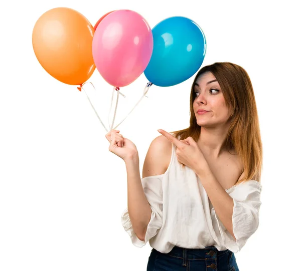 Schöne Junge Mädchen Hält Einen Luftballon Und Zeigt Auf Die — Stockfoto