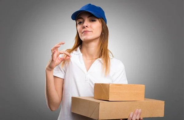 Delivery woman proud of herself on grey background