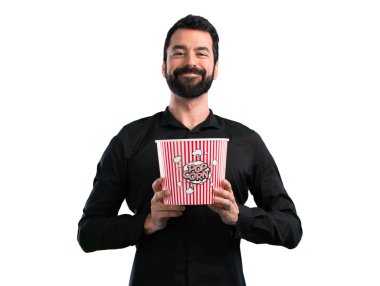 Popcorns beyaz arka plan üzerinde yemek sakallı yakışıklı adam