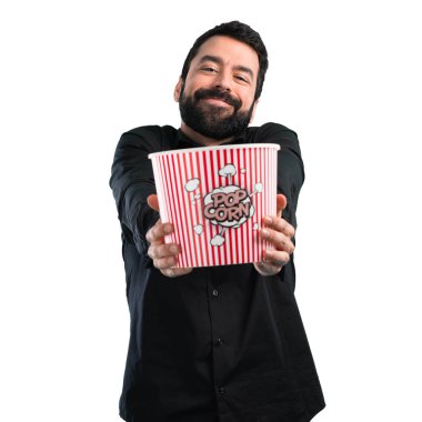 Popcorns beyaz arka plan üzerinde yemek sakallı yakışıklı adam