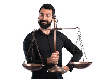 Beyaz arka plan üzerinde bir denge holding sakallı yakışıklı adam