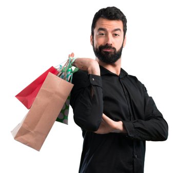 Beyaz arka plan üzerinde alışveriş çantası ile sakallı yakışıklı adam