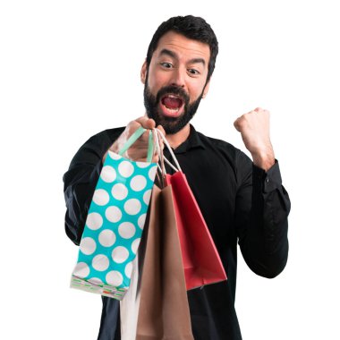 Beyaz arka plan üzerinde alışveriş çantası ile sakallı yakışıklı adam