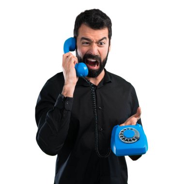 Beyaz arka plan üzerinde konuşmak için vintage telefon sakallı yakışıklı adam