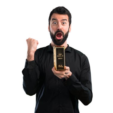 Beyaz zemin üzerine altın külçe ile sakallı yakışıklı adam