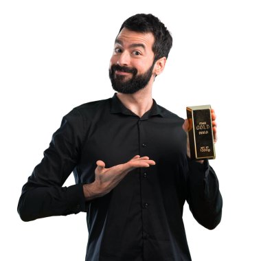 Beyaz zemin üzerine altın külçe ile sakallı yakışıklı adam