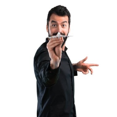 Beyaz arka plan üzerinde bir oyuncak uçak holding sakallı yakışıklı adam