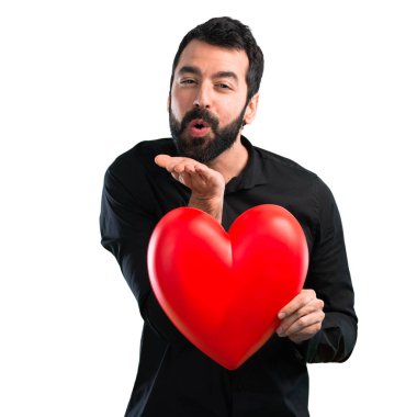 Beyaz arka plan üzerinde tutmak bir kalp oyuncak sakallı yakışıklı adam