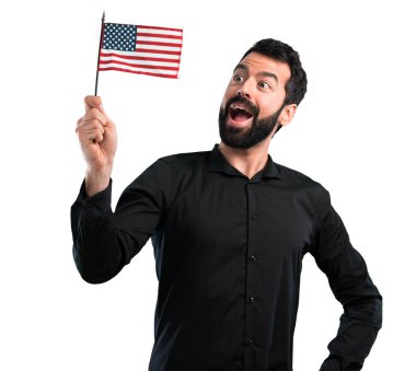 Bir Amerikan bayrağı beyaz arka plan üzerinde tutarak sakallı yakışıklı adam