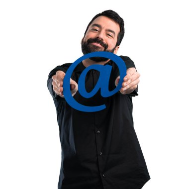 Beyaz arka plan üzerinde nokta com simgesi tutan sakallı yakışıklı adam