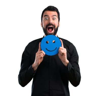 Mutlu yüz simgesi beyaz arka plan üzerinde tutarak sakallı yakışıklı adam