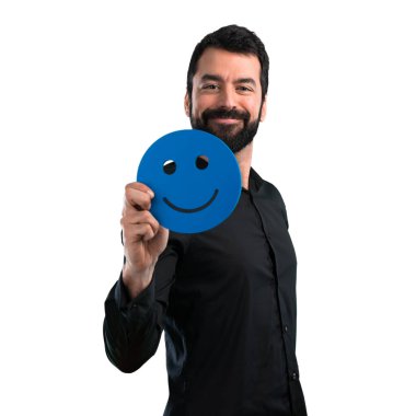 Mutlu yüz simgesi beyaz arka plan üzerinde tutarak sakallı yakışıklı adam