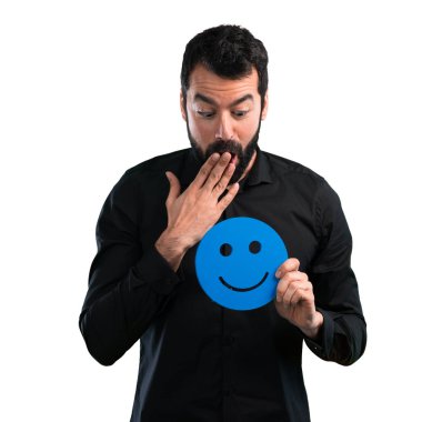 Mutlu yüz simgesi beyaz arka plan üzerinde tutarak sakallı yakışıklı adam