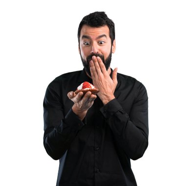 Beyaz zemin üzerine pasta ile sakallı yakışıklı adam