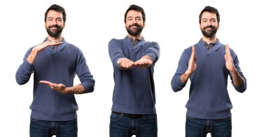 Bir şey tutan sakallı yakışıklı esmer adam kümesi