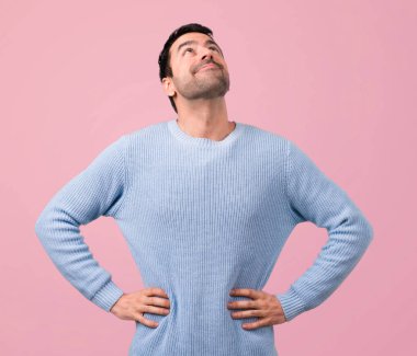 Yakışıklı adam stand ve pembe arka plan ararken