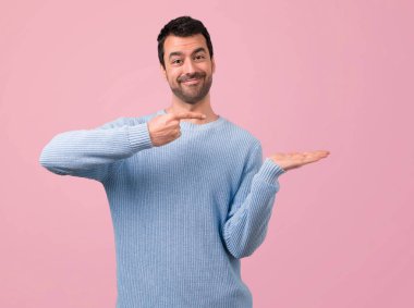 Yakışıklı adam pembe bir arka plan üzerinde Palm'da boşaltmak hayali holding