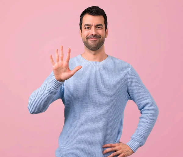 Man Med Blå Tröja Räknar Fem Med Fingrar Rosa Bakgrund — Stockfoto