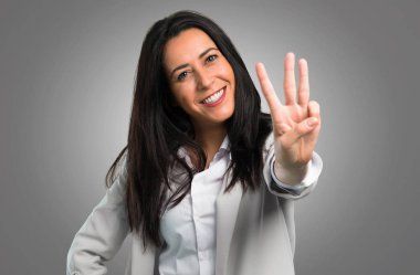 Güzel kadın üç gri arka plan üzerinde sayma