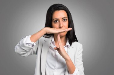 Güzel kadın yapma zaman aşımı jest gri arka plan üzerinde