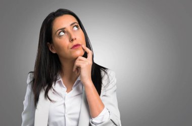 Güzel kadın gri arka plan üzerinde düşünme