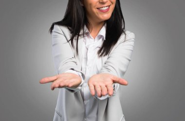 Güzel kadın bir şey gri arka plan üzerinde sunulması