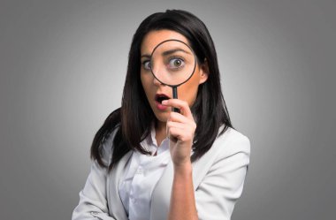 Gri arka plan üzerinde büyüteç ile güzel kadın