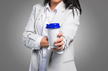 Gri arka plan üzerinde götürmeye kahve tutan güzel kadın